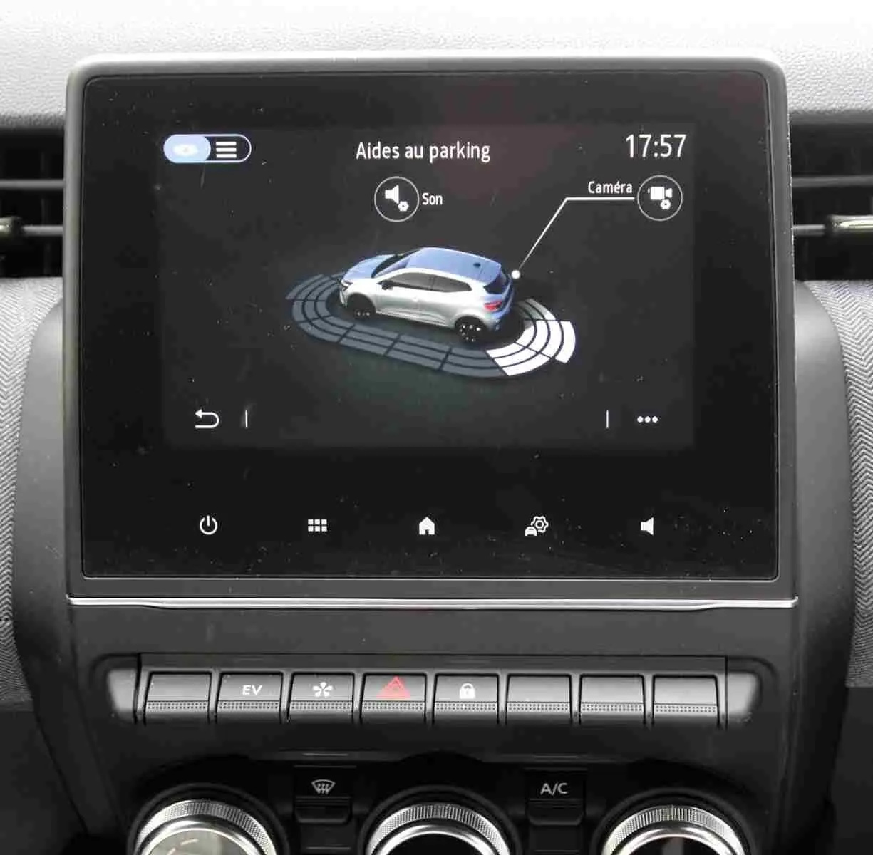 Écran tactile intérieur montrant l'aide au parking avec représentation 3D d'une Renault Clio vue de dessus en gris.