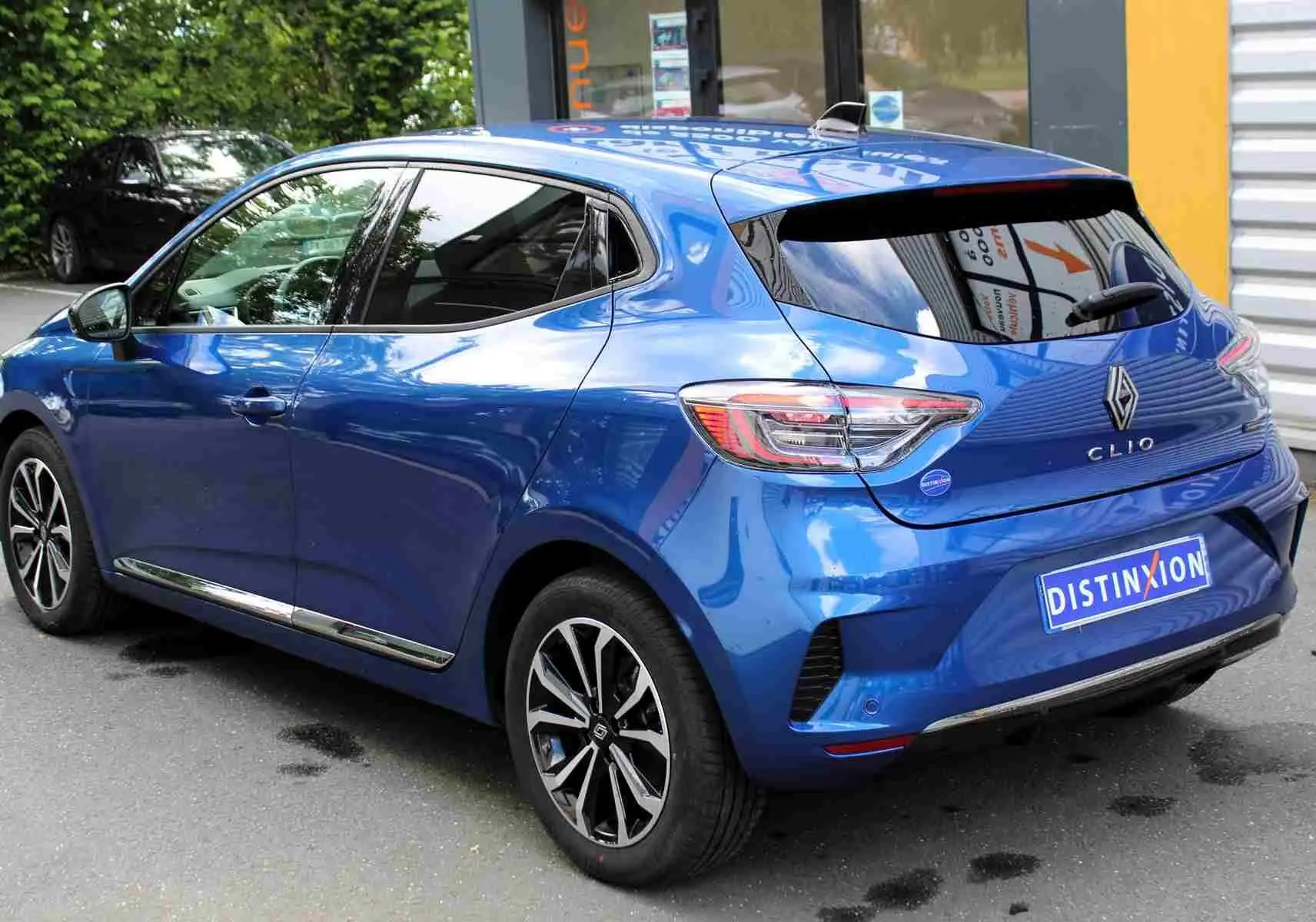 Renault Clio hybride bleu Iron Metal vue 3/4 avant droit, avec calandre noire et feux LED en forme de C.