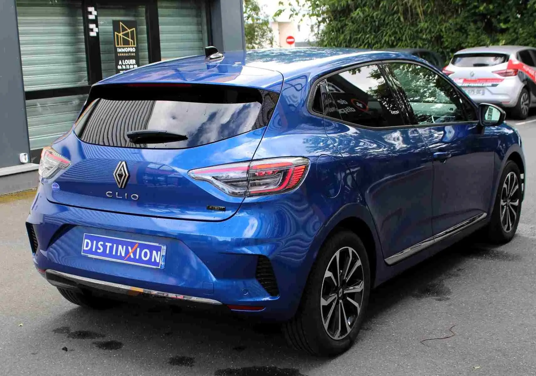 Vue 3/4 arrière droite d'une Renault Clio 2025 bleu iron metal avec jantes alliage et vitres teintées.