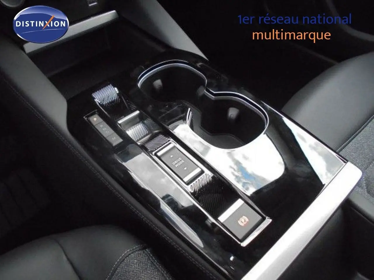 Gros plan sur la console centrale noire brillante avec porte-gobelets du Citroën C5 X blanc métal 2023.