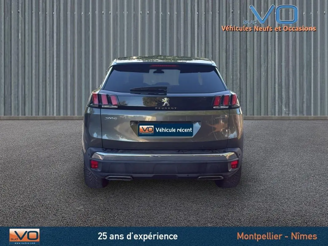 Vue arrière d'un Peugeot 3008 gris foncé de 2018 avec feux arrière caractéristiques et double sortie d'échappement.