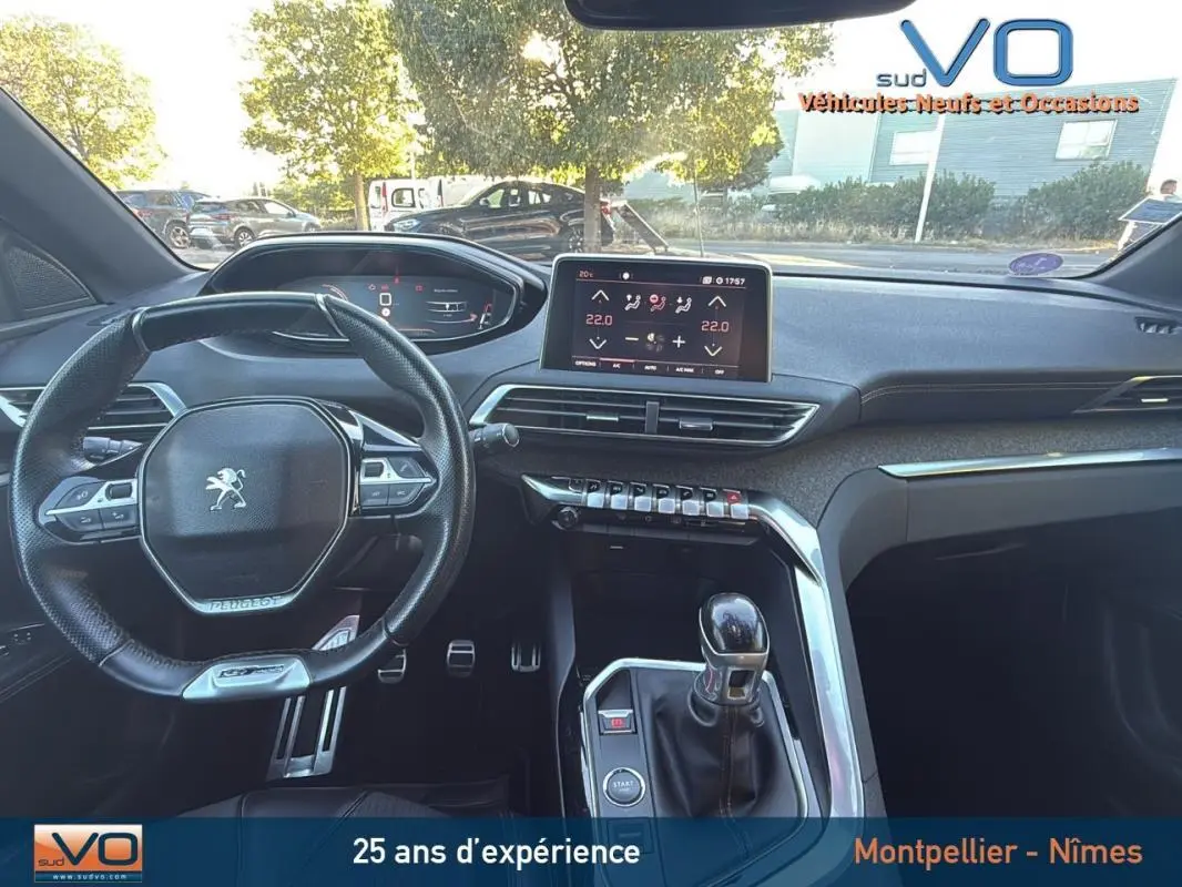 Intérieur du Peugeot 3008 gris foncé, vue du poste de conduite avec volant cuir, écran tactile et levier de vitesses manuel.