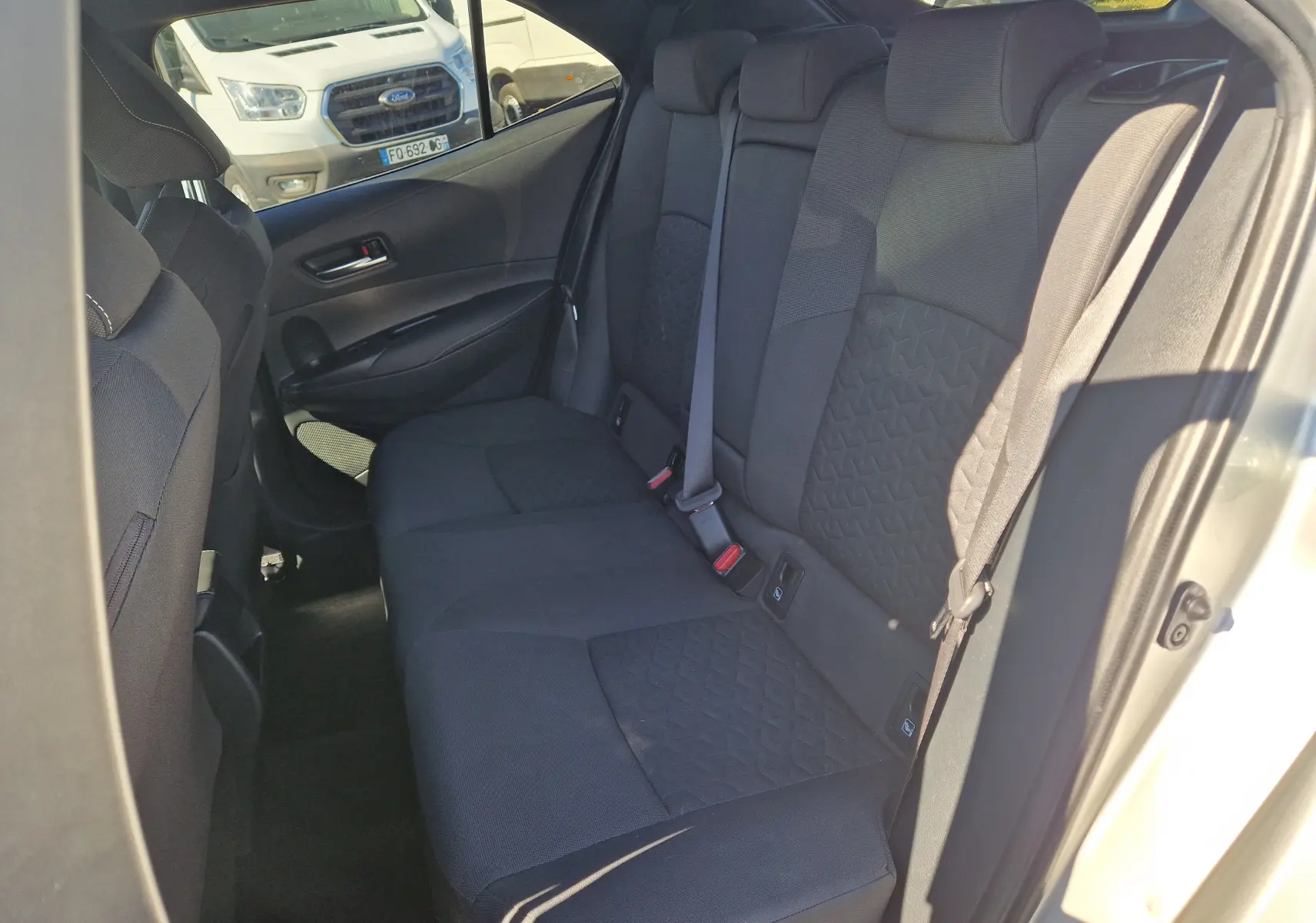 Vue intérieure côté droit des sièges arrière noirs avec motifs géométriques d'une Toyota Corolla Hybride 2019 gris clair métal.