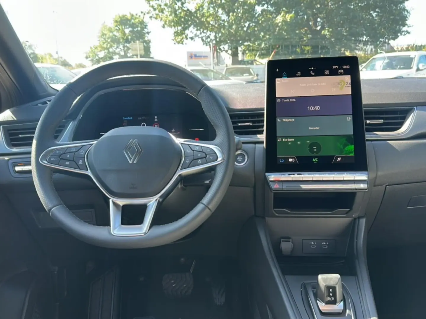 Intérieur Renault Captur 2026 vu de face, volant multifonction et grand écran tactile central.