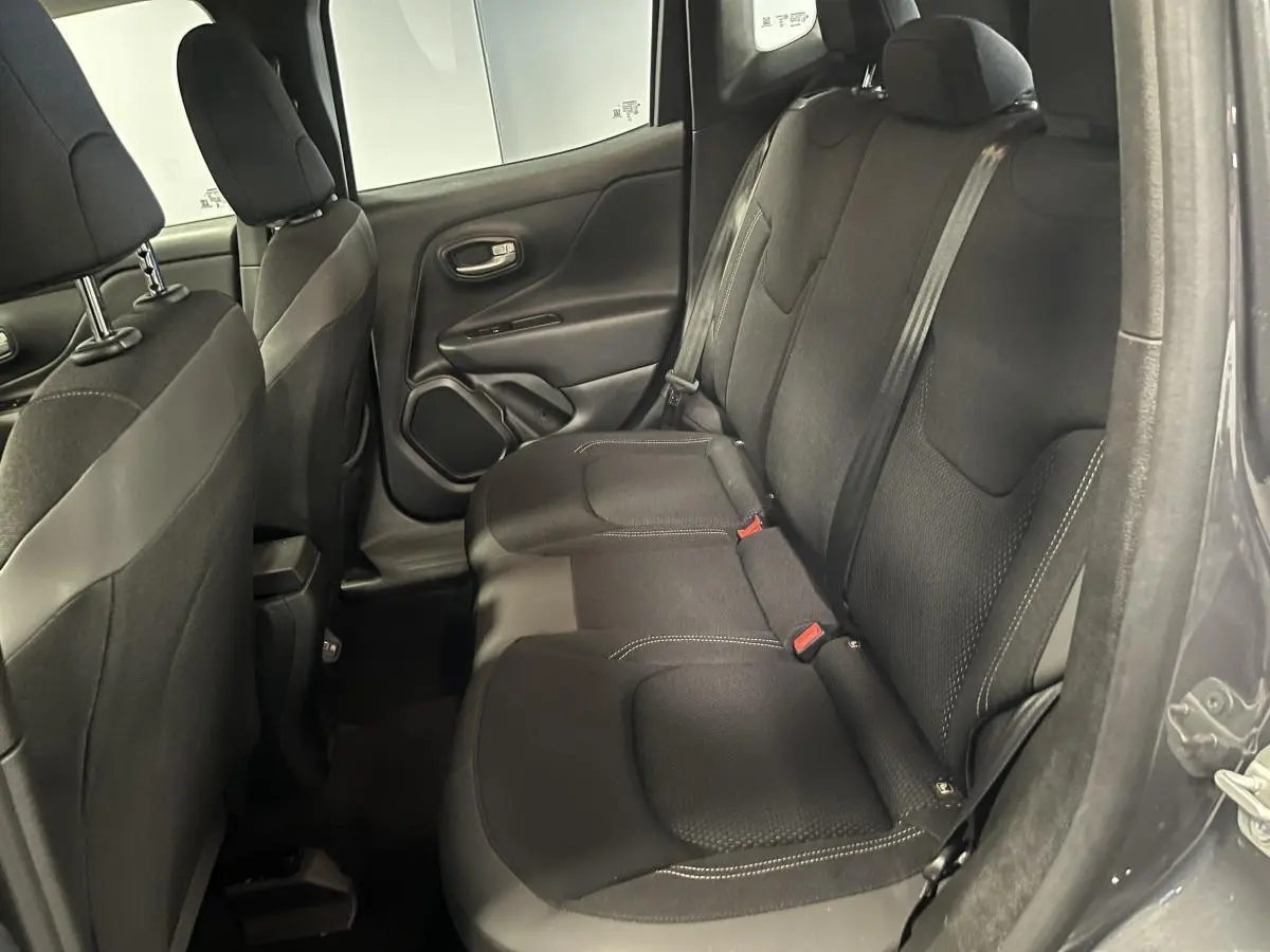Vue intérieure côté droit des sièges arrière en tissu noir du Jeep Renegade gris 2024, avec ceintures de sécurité visibles.