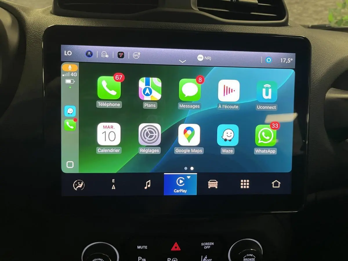 Écran tactile central du Jeep Renegade 2024 affichant Apple CarPlay avec icônes colorées et commandes en dessous.