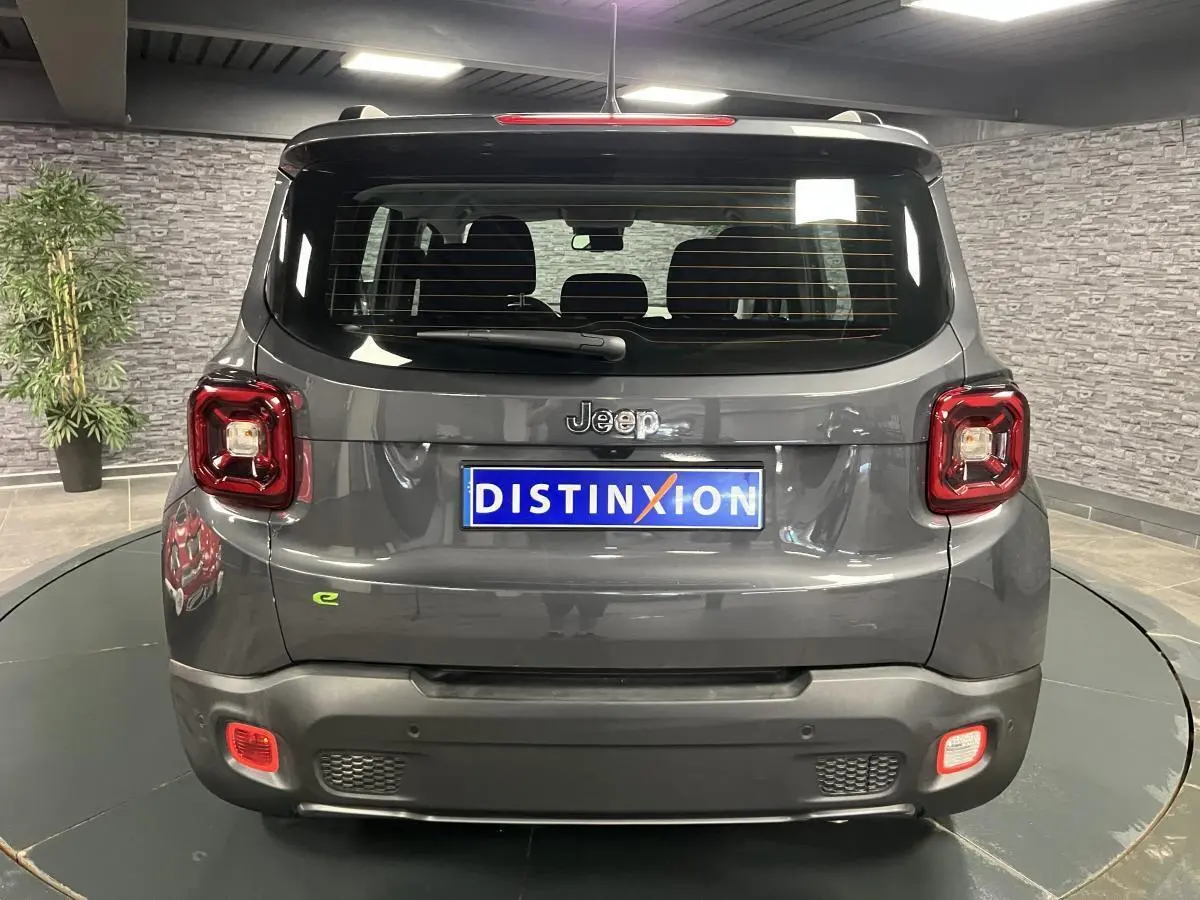 Vue arrière d'un Jeep Renegade gris métallisé avec feux carrés et logo e-Hybride vert sur le coffre