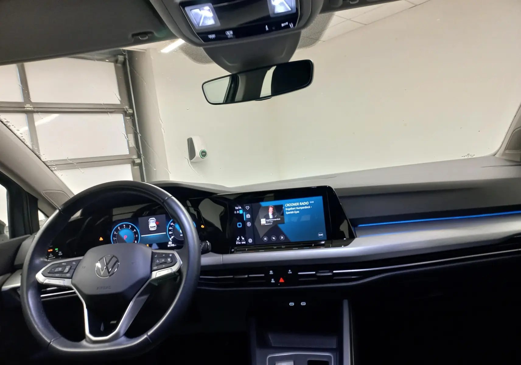 Tableau de bord et volant de la Volkswagen Golf 1.5 TSI 130 DSG7 Life Plus 2023 avec éclairage d'ambiance bleu.