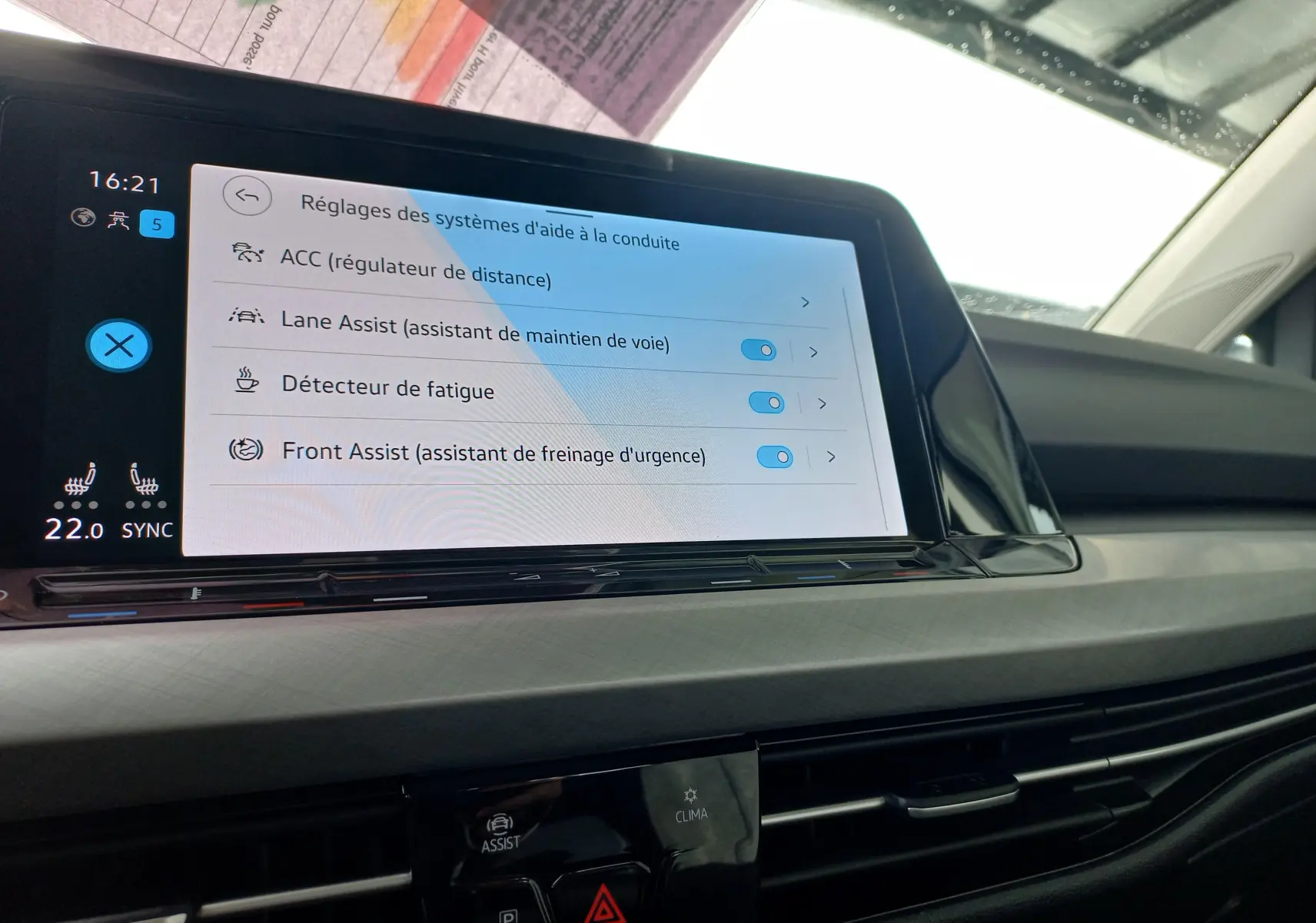 Écran tactile du tableau de bord de la Volkswagen Golf 1.5 TSI 130 DSG7 Life Plus 2023 montrant les aides à la conduite activées.