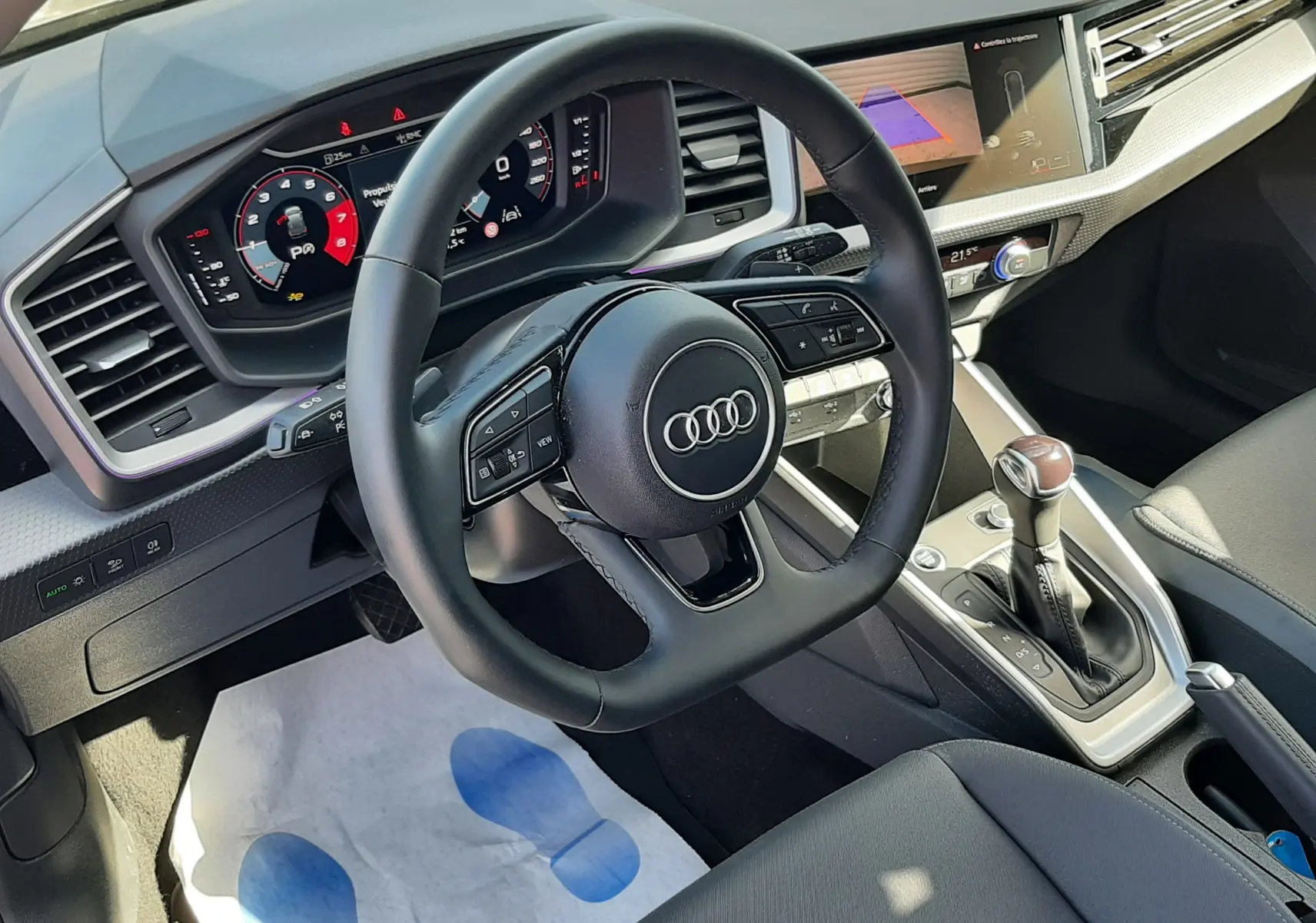 Vue intérieure de l'Audi A1 Sportback 2025, volant cuir sport, tableau de bord digital et levier de vitesse automatique.