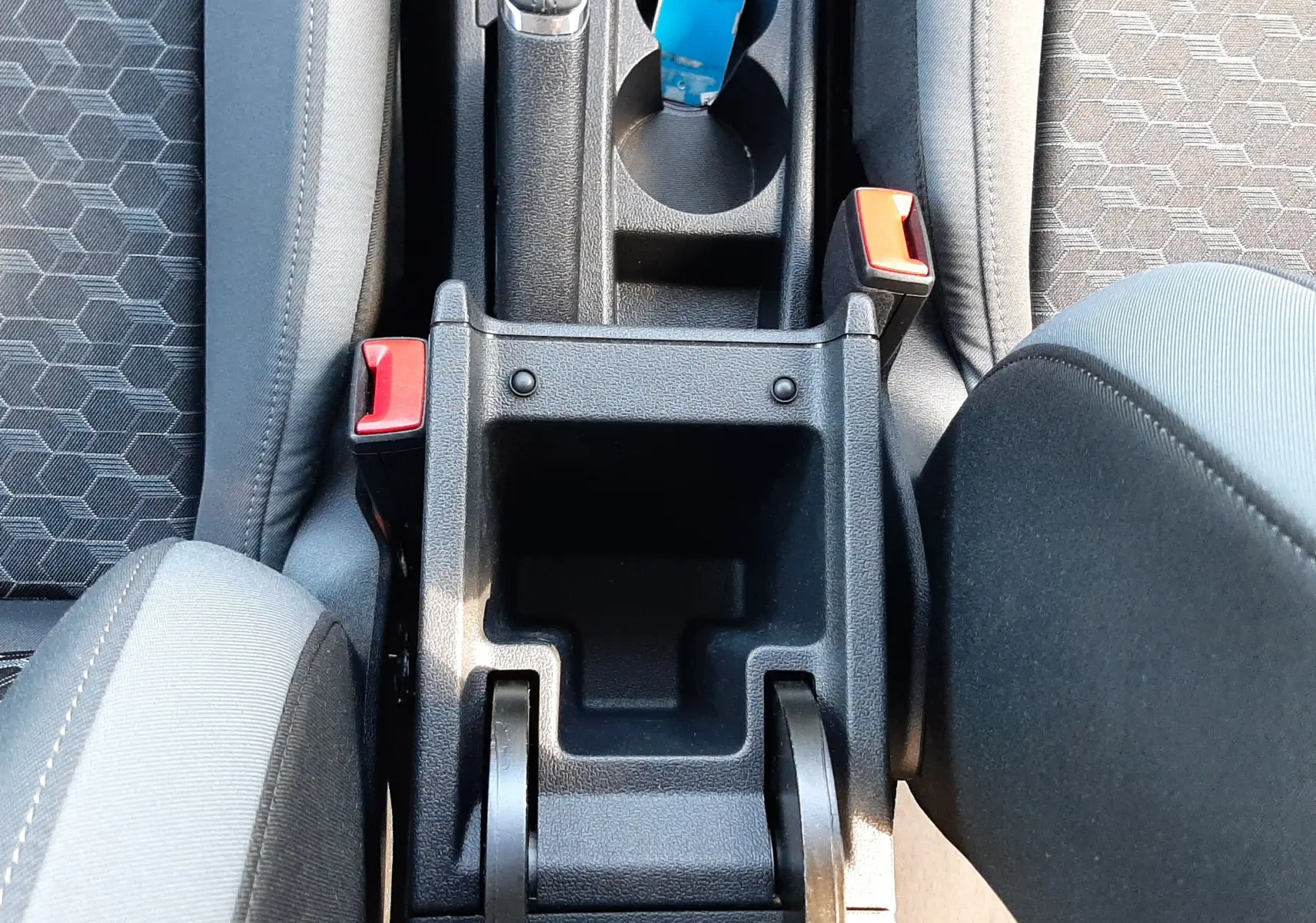 Vue plongeante sur la console centrale noire de l'Audi A1 Sportback 30 TFSI avec sièges tissu gris à motifs hexagonaux.