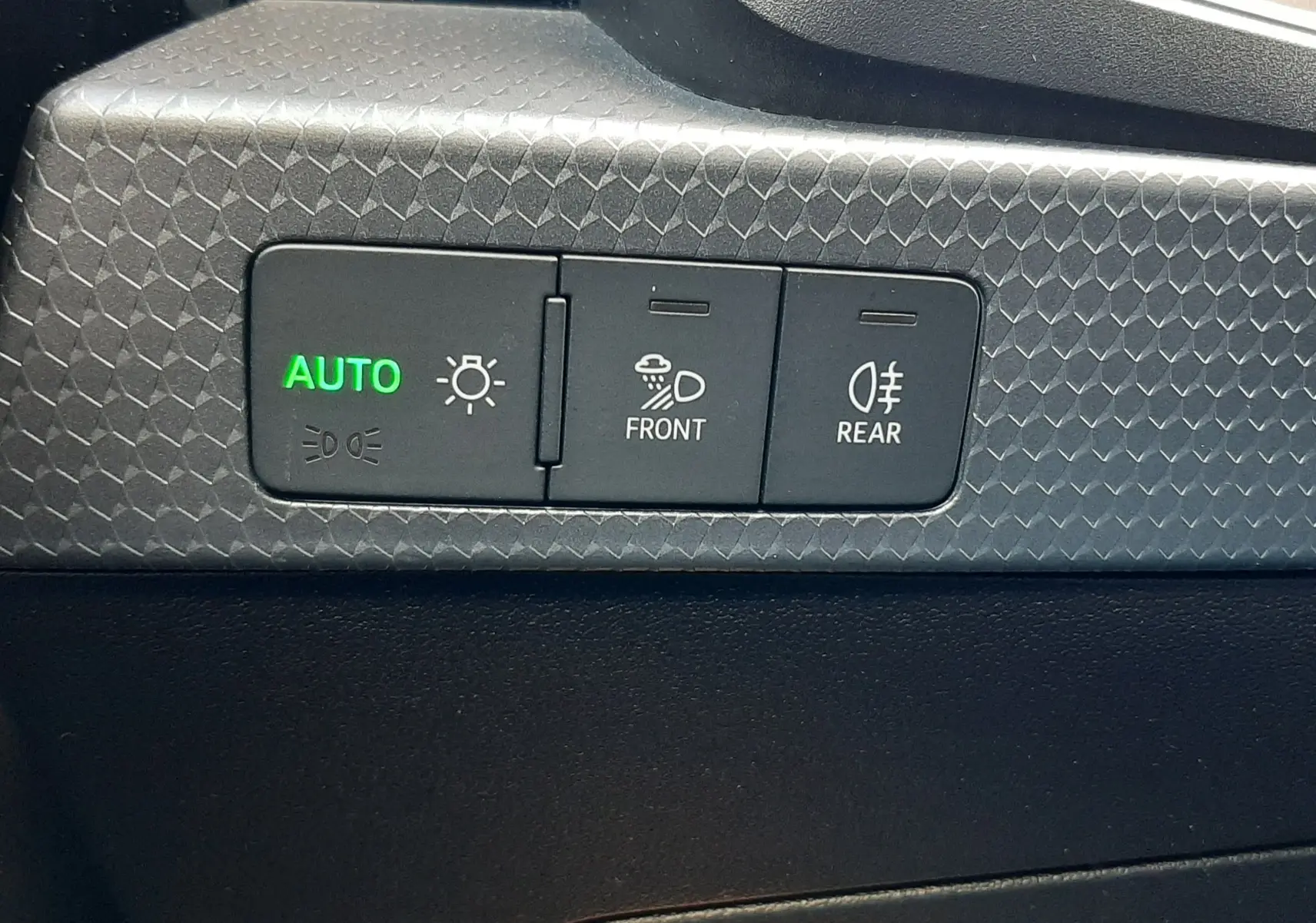 Gros plan sur les commandes d’éclairage intérieures de l’Audi A1 Sportback 2025 avec bouton auto allumé en vert.