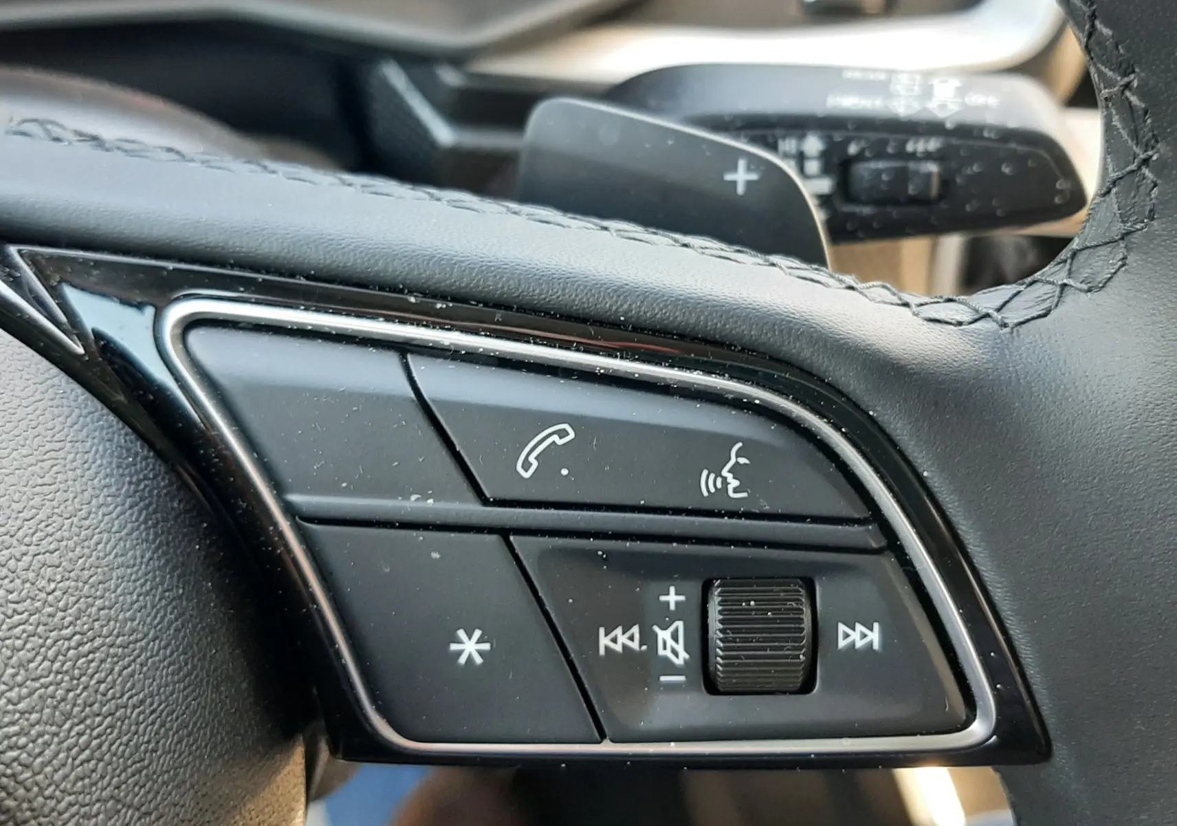 Gros plan sur les commandes multifonctions du volant cuir noir de l'Audi A1 Sportback 2025, finition S-Line.