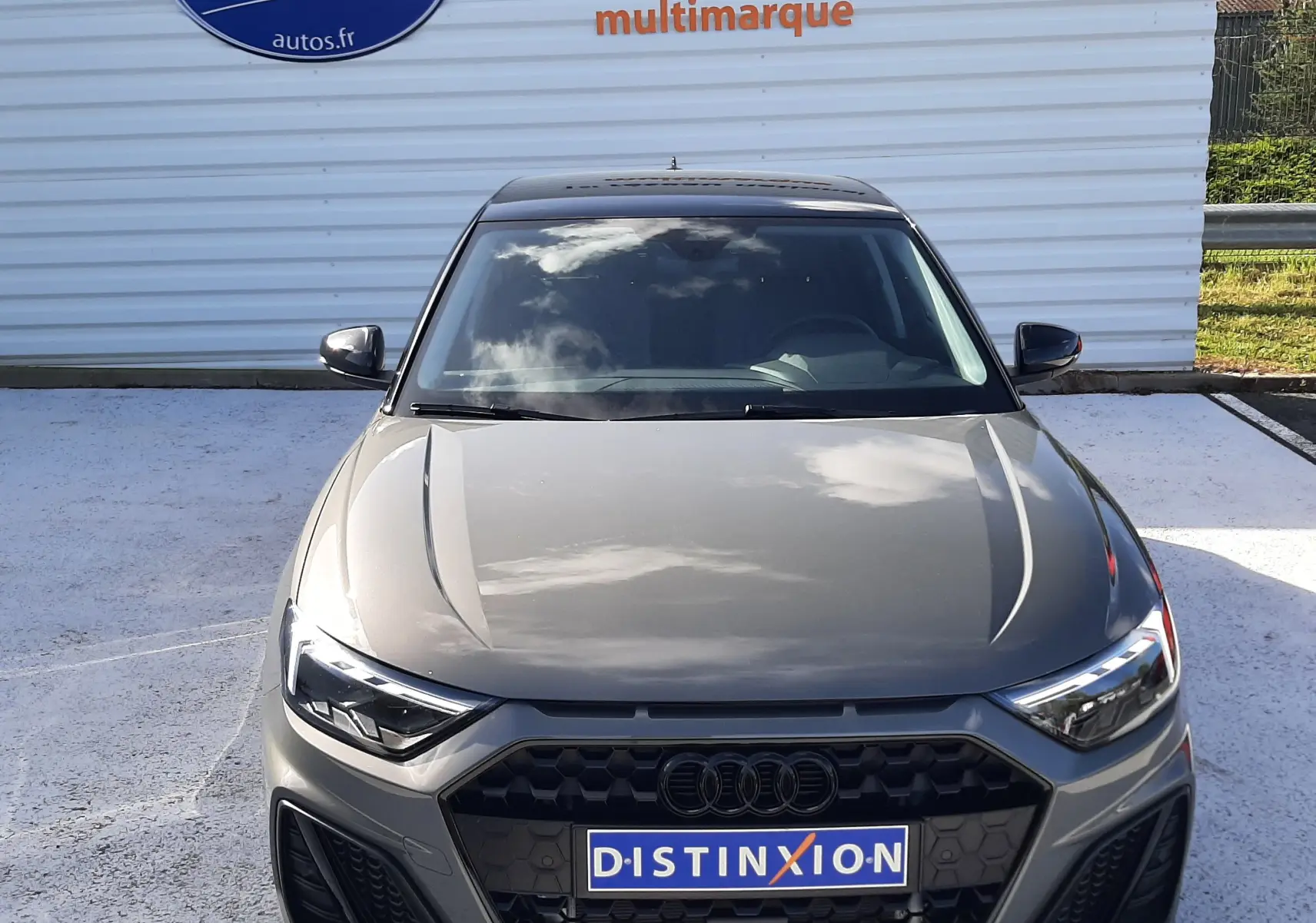 Audi A1 Sportback gris Chronos avec toit noir, vue de face mettant en valeur sa calandre hexagonale et ses phares LED.