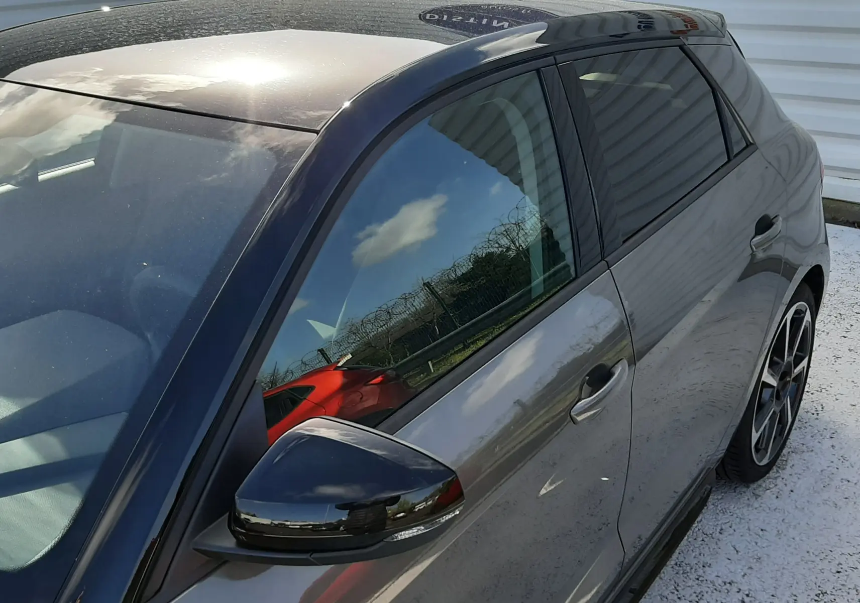 Vue 3/4 avant droit d'une Audi A1 Sportback 2025 gris Chronos avec toit noir et jantes alu 18 pouces en hélice.