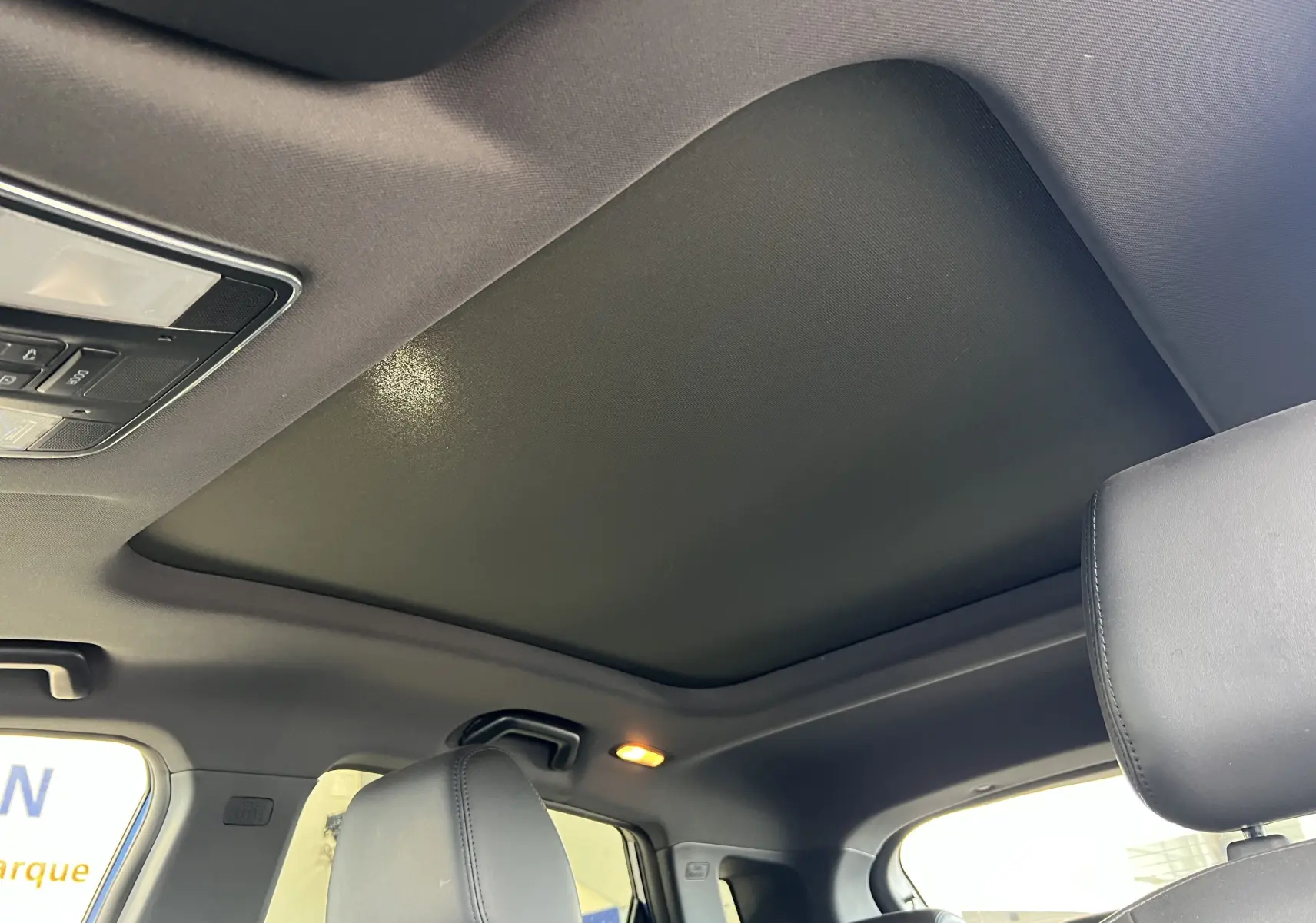 Toit ouvrant panoramique fermé et ciel de toit noir dans l'habitacle du SERES 3 Electric 163ch Luxe bleu astral métallisé.