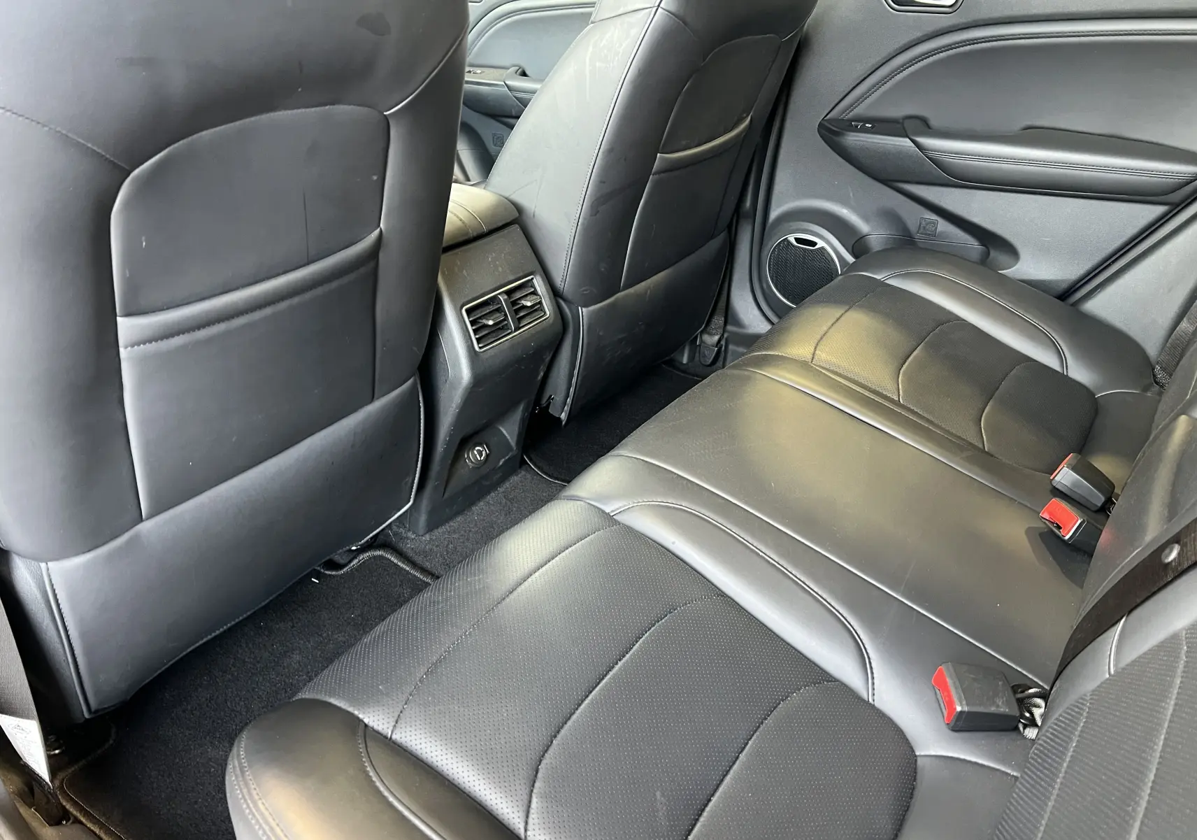 Vue arrière intérieure du SERES 3 Electric 2022 avec sièges en cuir noir et aérateurs centraux entre les sièges avant.