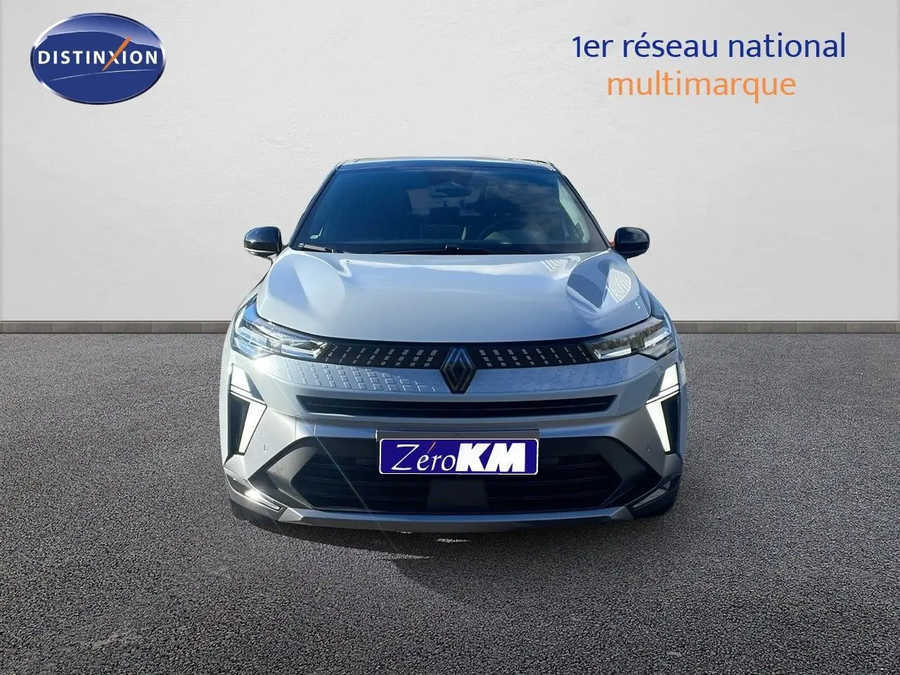 Vue frontale d'un Renault Captur E-Tech hybride gris Rafale métal avec toit noir, éclairage LED allumé.