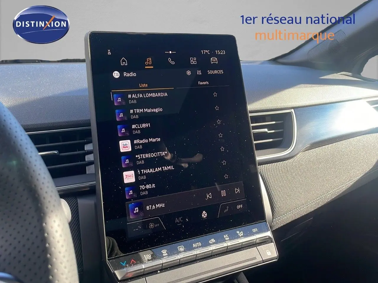Écran tactile central allumé dans l'habitacle du Renault Captur gris rafale métal avec toit noir, vue côté conducteur.