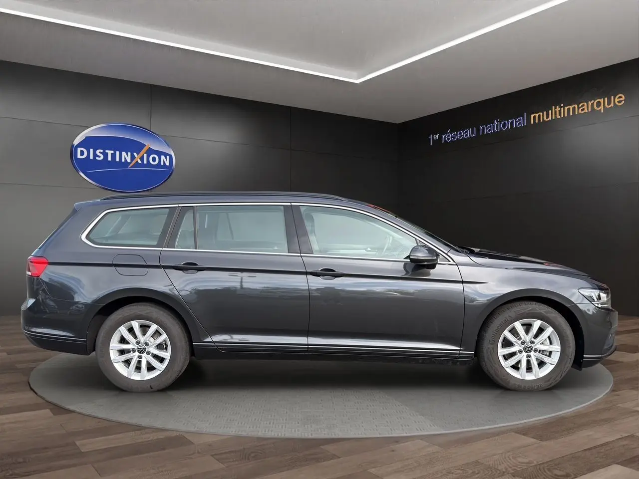 Volkswagen Passat SW gris manganese vue de profil côté gauche, jantes alliage et toit ouvrant visibles.