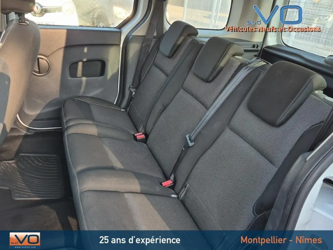 Vue intérieure côté droit du Renault Kangoo blanc 2016, montrant la banquette arrière en tissu noir.