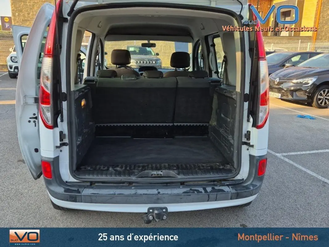 Vue arrière ouverte du Renault Kangoo blanc 2016 montrant le grand espace de chargement vide et les sièges arrière.