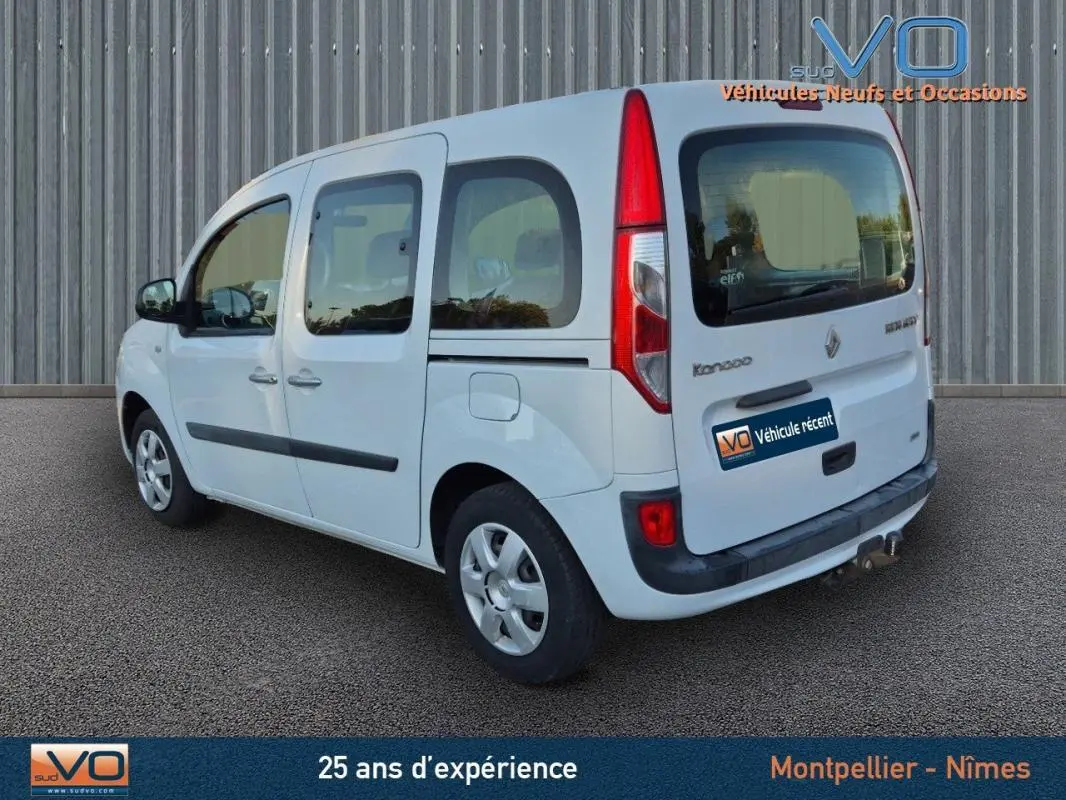 Vue 3/4 arrière droite du Renault Kangoo blanc 2016 avec porte latérale et vitres surteintées.