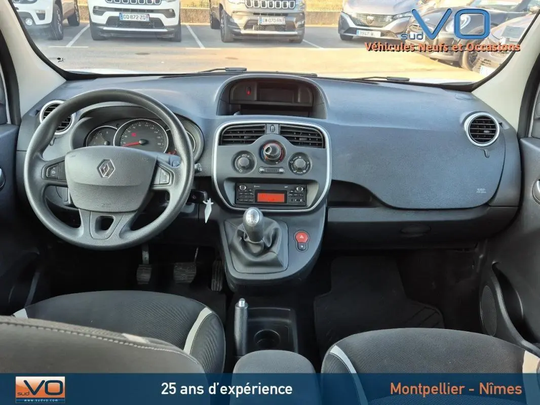 Vue intérieure du tableau de bord et volant du Renault Kangoo blanc 2016 avec boîte manuelle et commandes centrales visibles