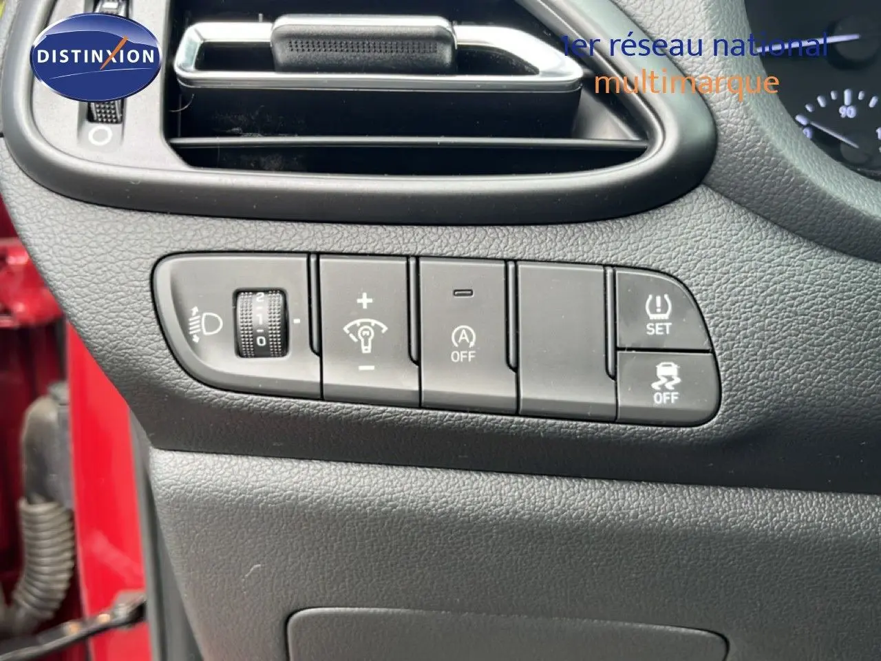 Gros plan sur les commandes de réglage du tableau de bord côté gauche d'une Hyundai i30 SW rouge Sunset Red 2023.