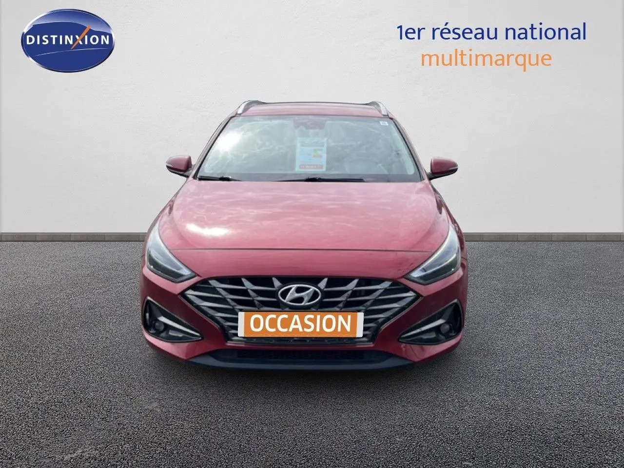 Vue avant d'une Hyundai i30 SW 2023 en rouge Sunset Red Metal avec calandre et phares LED distinctifs.