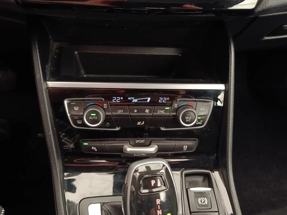 Vue rapprochée de la console centrale noire du BMW Série 2 Gran Tourer 218i Lounge avec commandes climatisation et levier de vitesse automatique.