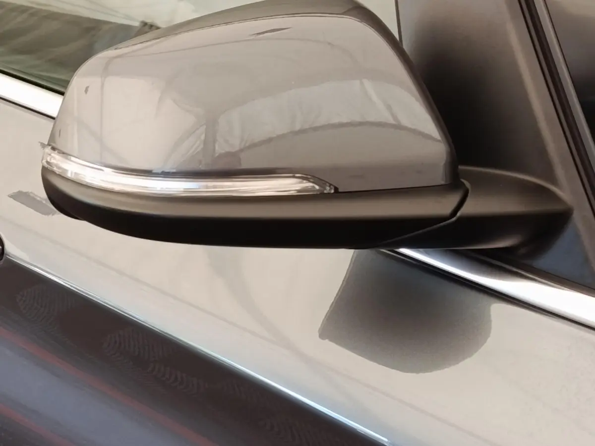Gros plan sur le rétroviseur droit gris clair de la BMW Série 2 Gran Tourer F46 218i Lounge 2022 avec clignotant intégré.