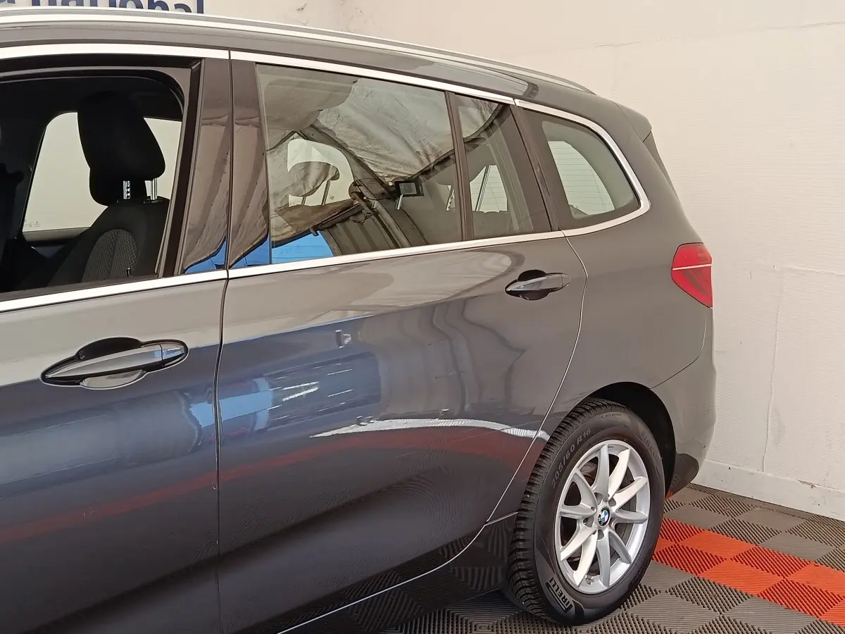Vue côté droit arrière d'une BMW Série 2 Gran Tourer F46 gris clair avec jantes alliage et vitres teintées.