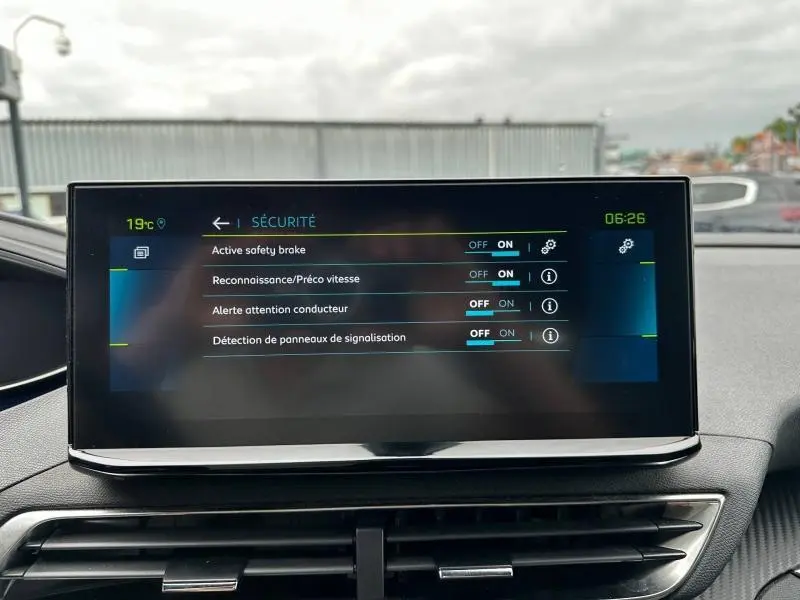 Écran tactile central du Peugeot 3008 Hybride noir, affichant les réglages de sécurité activés, vue intérieure frontale.