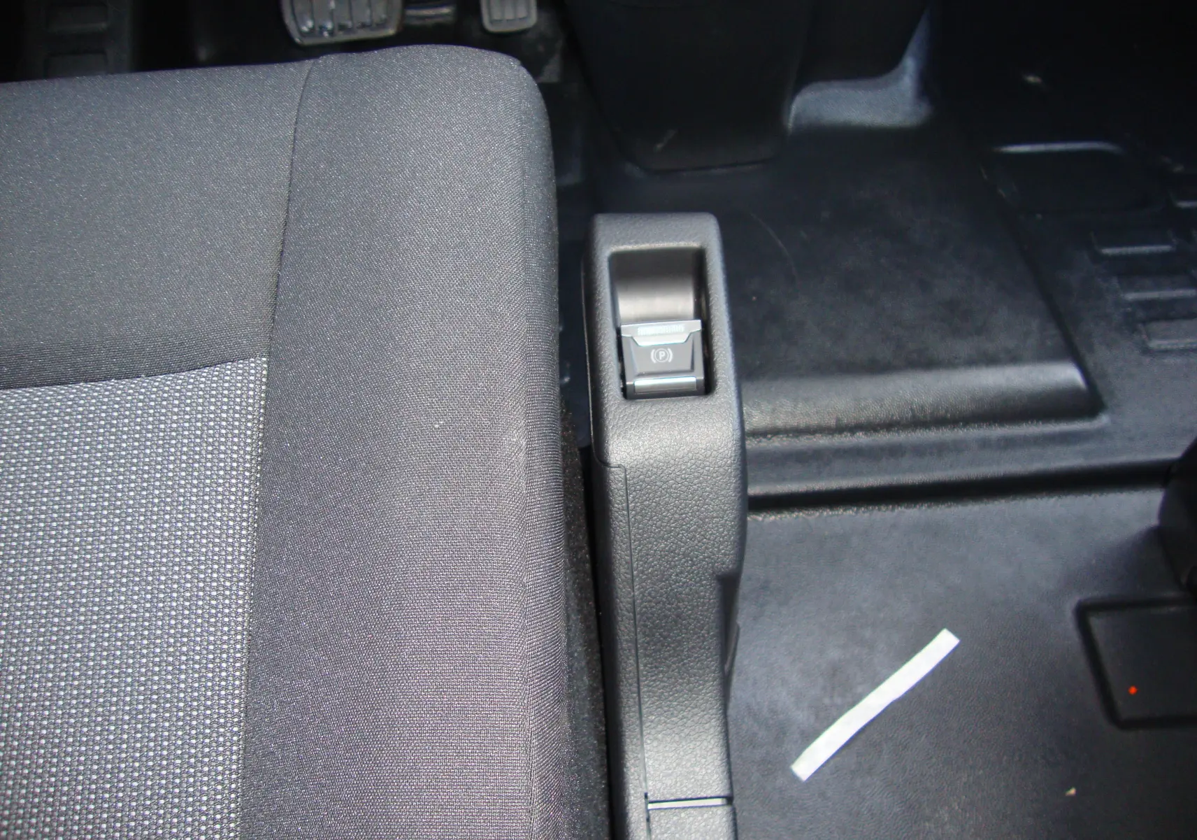 Gros plan sur le frein à main électrique et le siège conducteur en tissu gris du Citroën Jumpy Cabine Approfondie 2024.