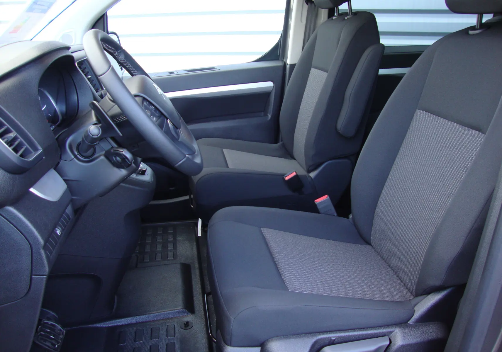 Vue intérieure côté conducteur du Citroën Jumpy Cabine Approfondie gris platinum, sièges tissu gris foncé et clair.