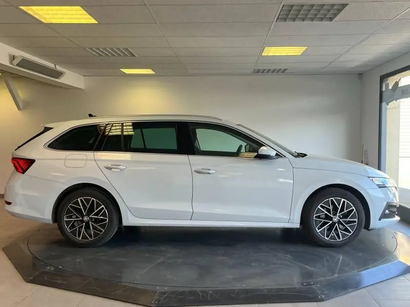 Vue latérale droite d'une Skoda Octavia Combi 2022 blanc cristal, avec jantes alliage et vitres teintées.