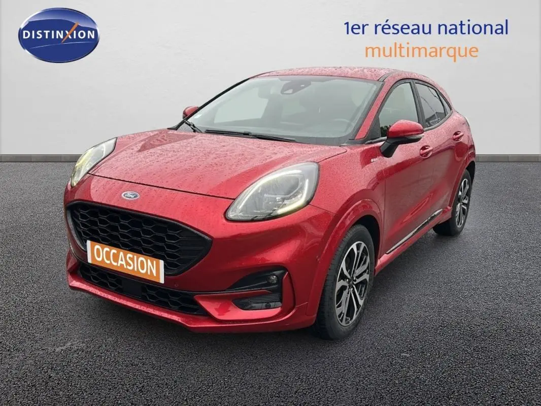 Vue 3/4 avant d'une Ford Puma rouge 2020 avec jantes alliage 17 pouces sur sol gris.