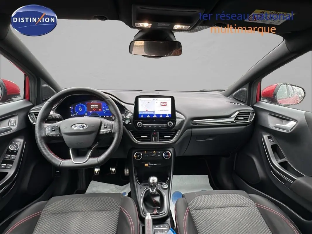 Vue intérieure avant du Ford Puma rouge 2020, avec tableau de bord numérique et écran tactile central.