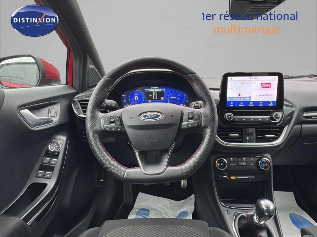 Vue intérieure frontale du Ford Puma rouge 2020, tableau de bord moderne avec écran tactile et volant multifonction.