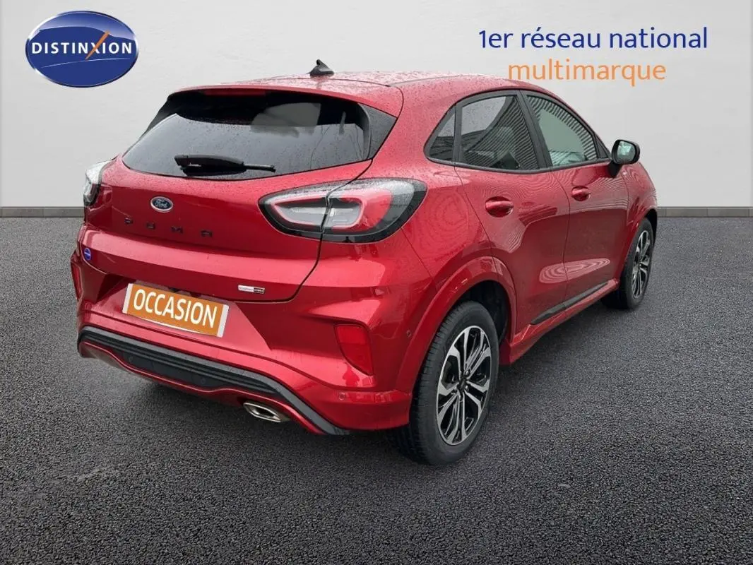 Vue 3/4 arrière droite d'une Ford Puma rouge 2020 avec jantes alliage 17 pouces et feux arrière LED distinctifs.