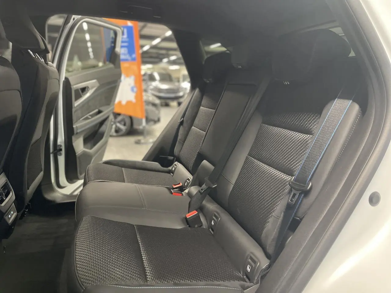 Vue intérieure côté droit des sièges arrière noirs en tissu Alcantara avec surpiqûres bleu blanc rouge du Renault Austral 2025.