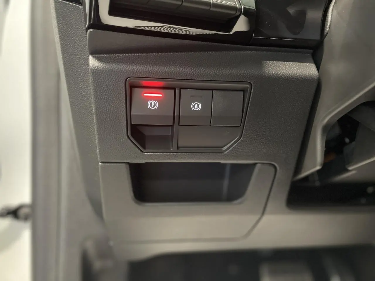 Gros plan sur les commandes du frein de parking électrique et du démarrage automatique dans un Renault Austral blanc nacré.