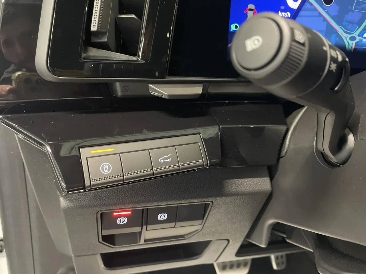 Détail intérieur côté gauche du tableau de bord noir brillant du Renault Austral 2025 avec commandes électroniques et levier d'essuie-glace.