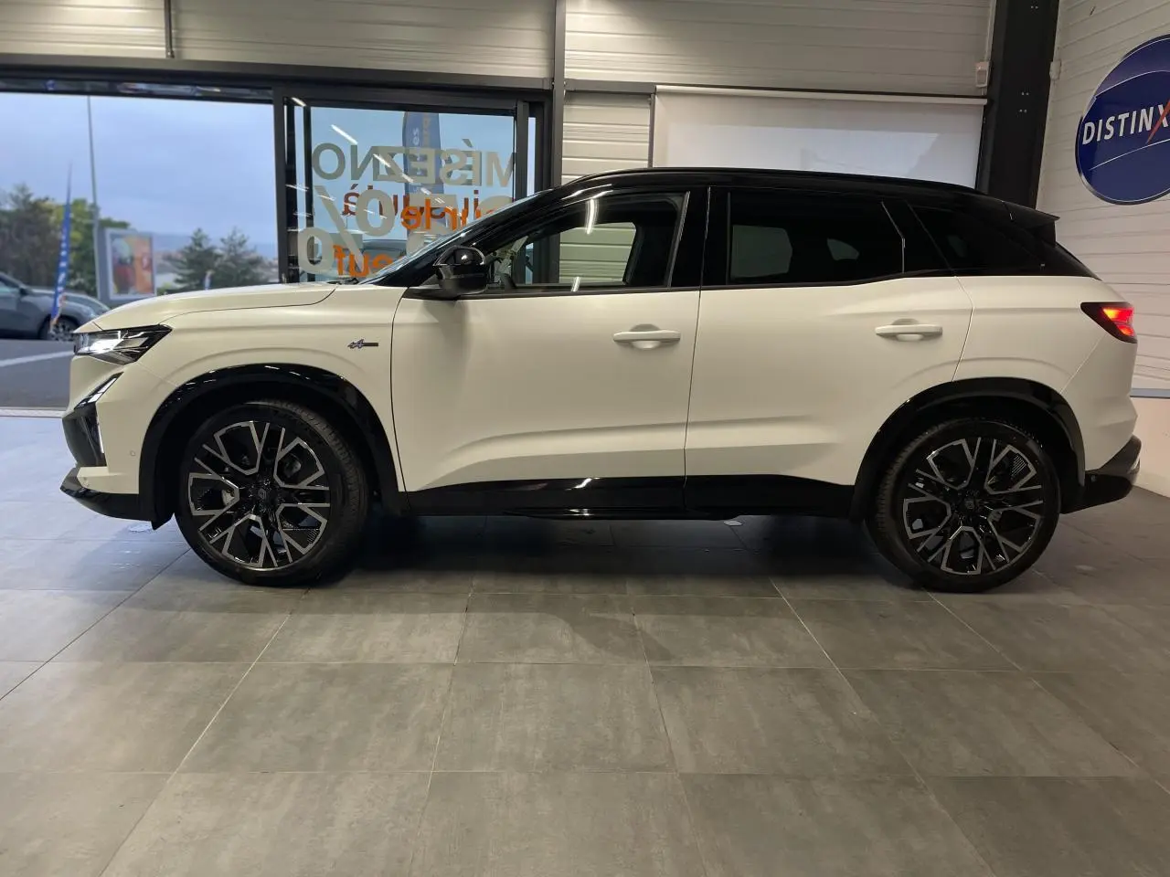 Profil droit du Renault Austral 2025 blanc nacré satin avec toit noir et jantes alliage noires diamantées.