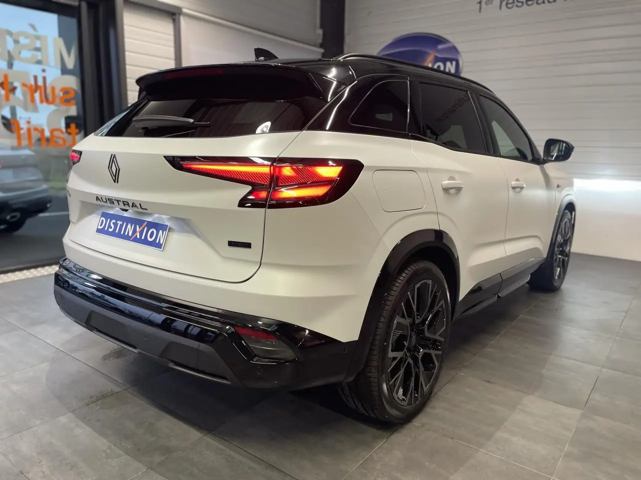 Vue 3/4 arrière droite du Renault Austral blanc nacré avec toit noir et jantes alliage noires satinées.