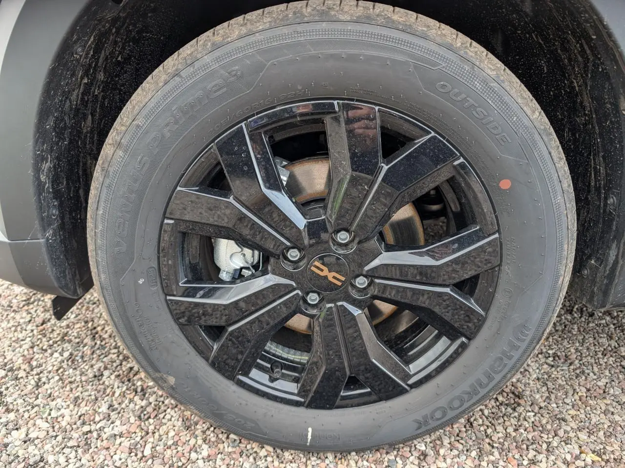 Gros plan sur la jante aluminium noire 16 pouces Mahalia du Dacia Jogger vert métallisé, avec pneu Hankook.