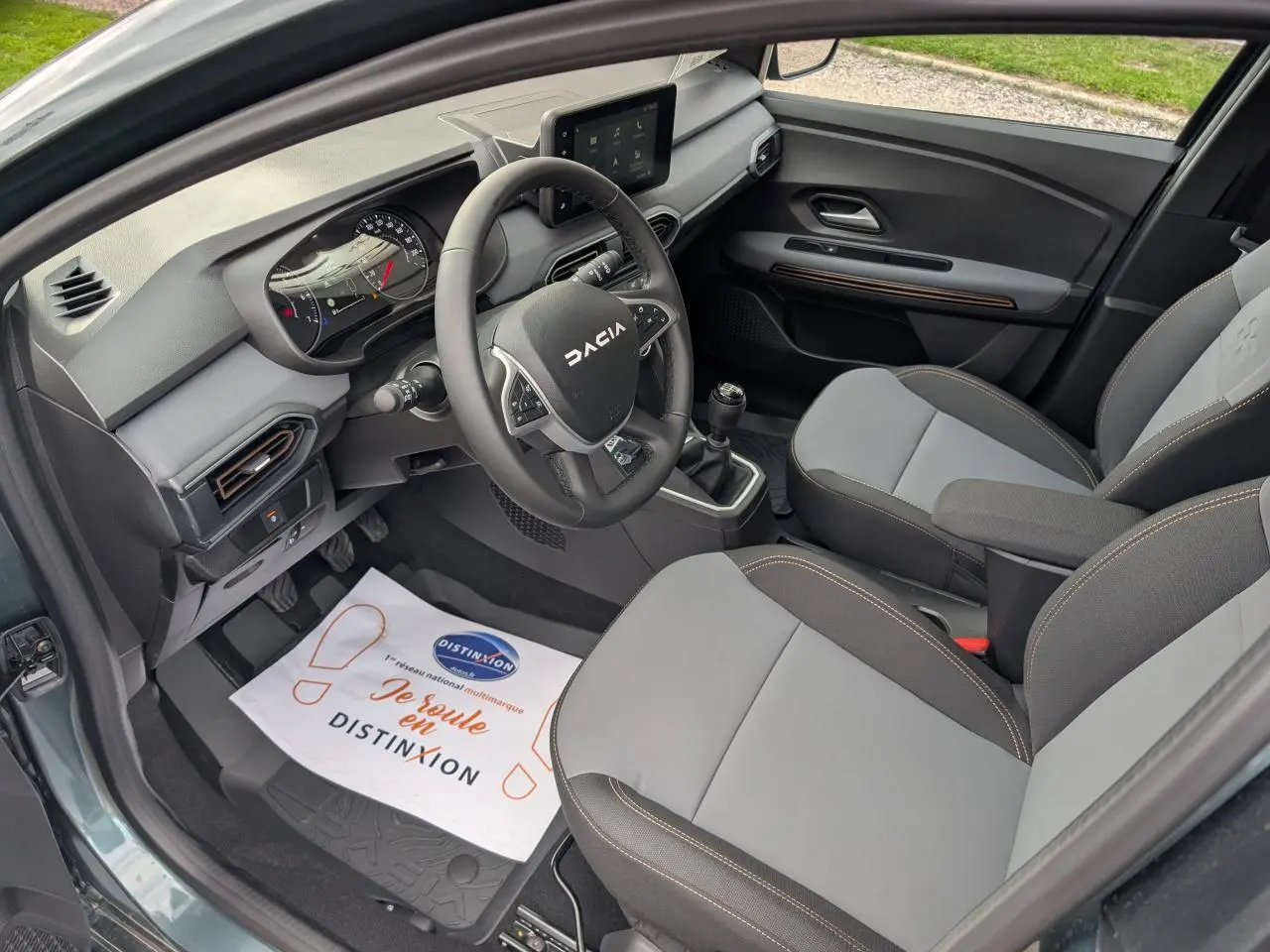 Vue intérieure côté conducteur du Dacia Jogger 2025 avec sellerie grise et volant multifonction noir.