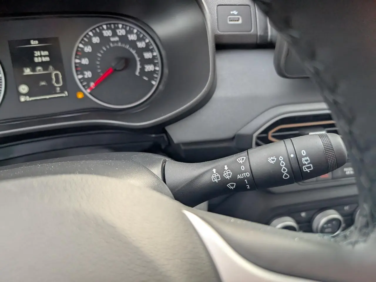 Vue intérieure rapprochée du commodo d’essuie-glace et du tableau de bord gris d’un Dacia Jogger 2025.