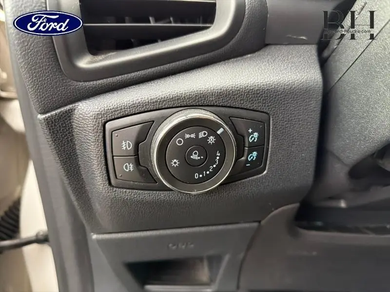 Gros plan sur le bouton de commande des phares du Ford EcoSport 2020, intérieur noir avec détails lumineux bleus.